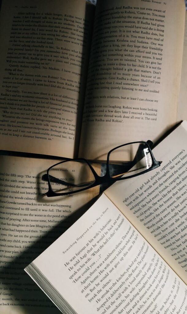 An intimate view of open books and eyeglasses arranged on a table, offering a cozy reading atmosphere.